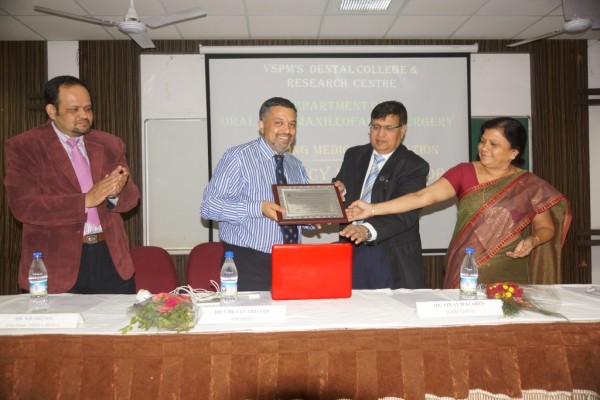  Dr. Vinay Hazarey felicitating Dr. Chetan Trivedy while Dr. Radke and Dr. Shenoi look on.